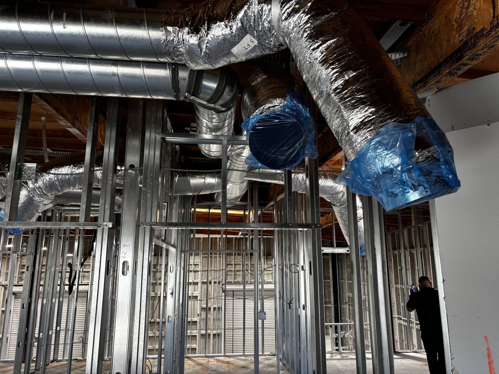 Insulated flexible ducts branching from a trunk line above steel framing.